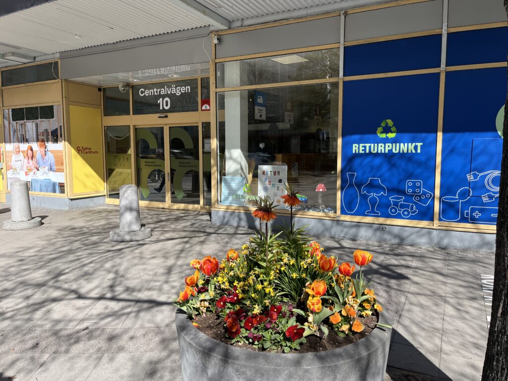 Entré Centralvägen 10 Solna centrum med Returpunktens skyltfönster till höger